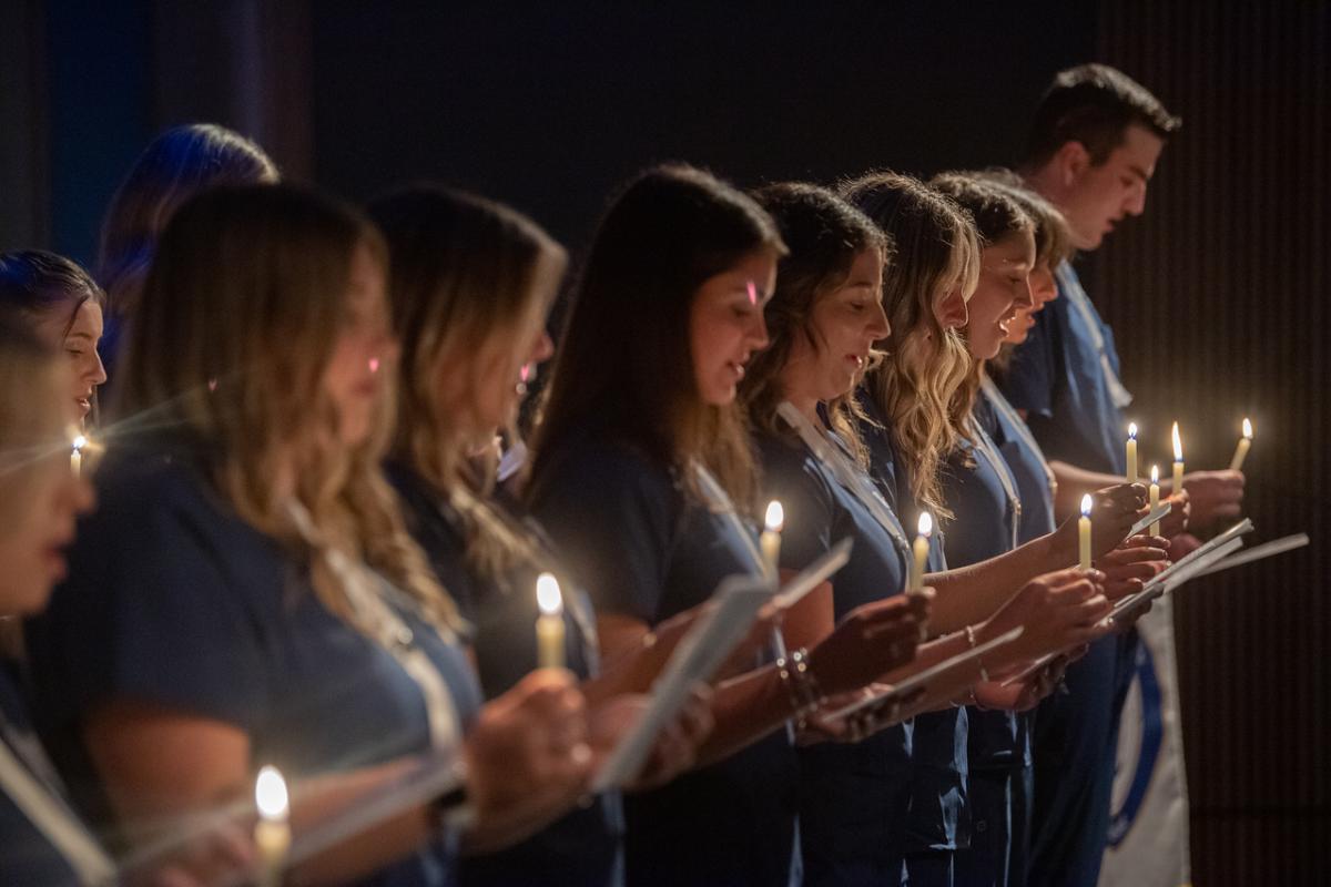 Nursing students holding candles at the Nursing Pinning Ceremony.