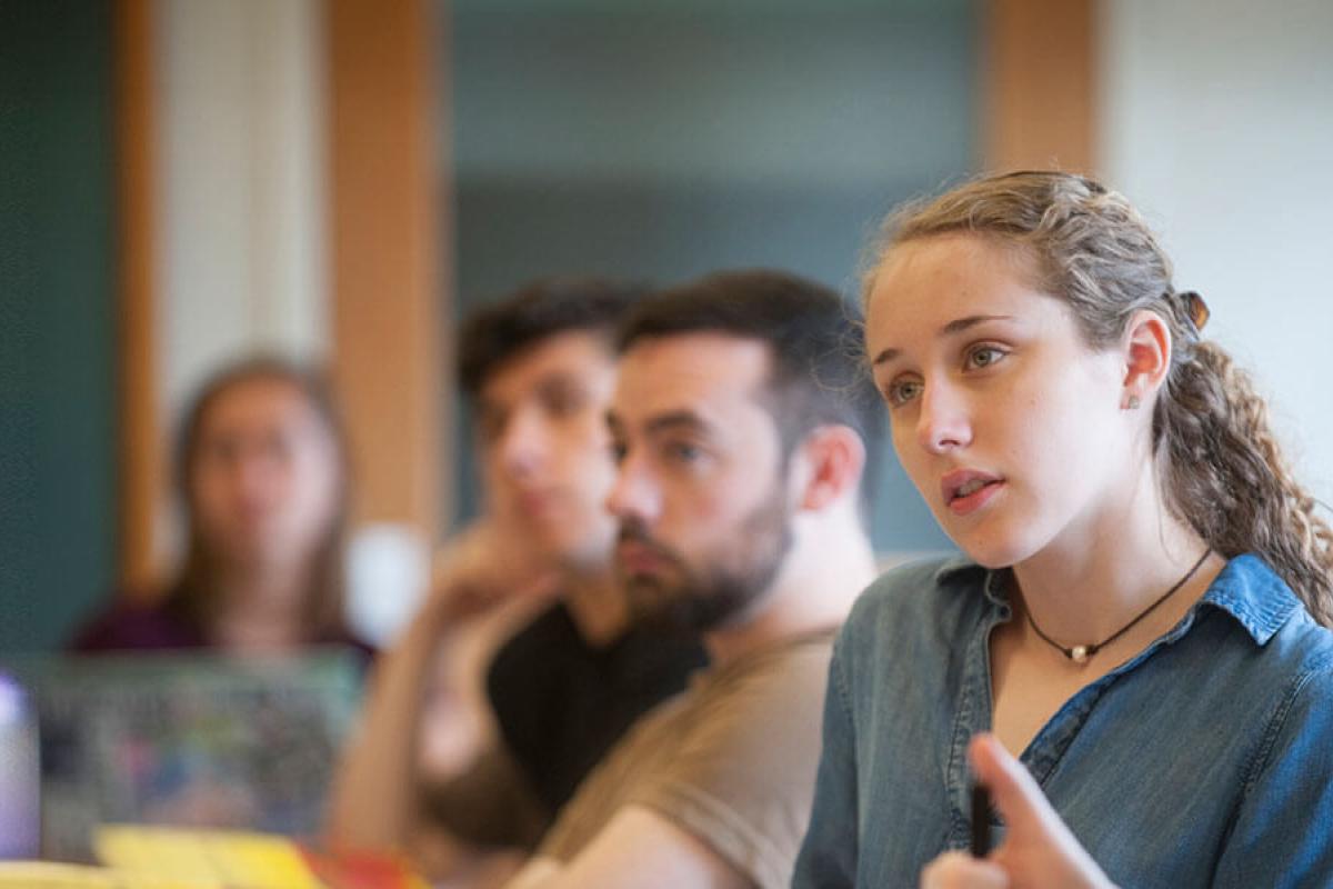 Several Westfield University students sit in a classroom listening intently to their instructor.