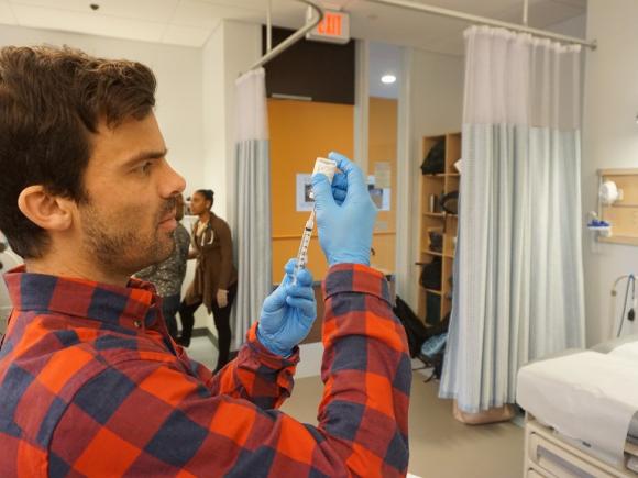 A male student fills a syringe in the Sim lab in the Stevens Science Center