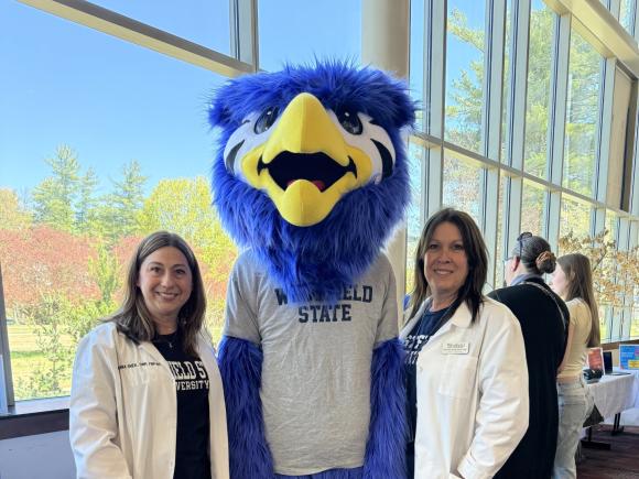 Two staff members from Health Services stand smiling with Nestor.