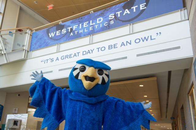 Nestor the Owl, with arms spread wide, beneath a sign that says, "It's a great day to be an owl"