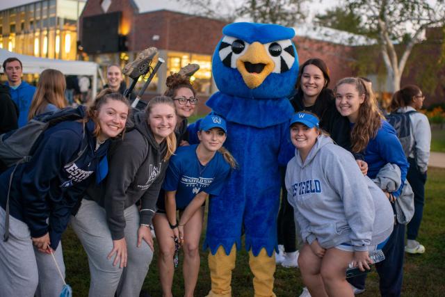 Pep rally on the campus green at Westfield State University featuring a group of athletic students with Nestor in the center.