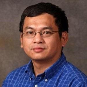 Dr. Liem Nguyen wearing blue plaid shirt and glasses.