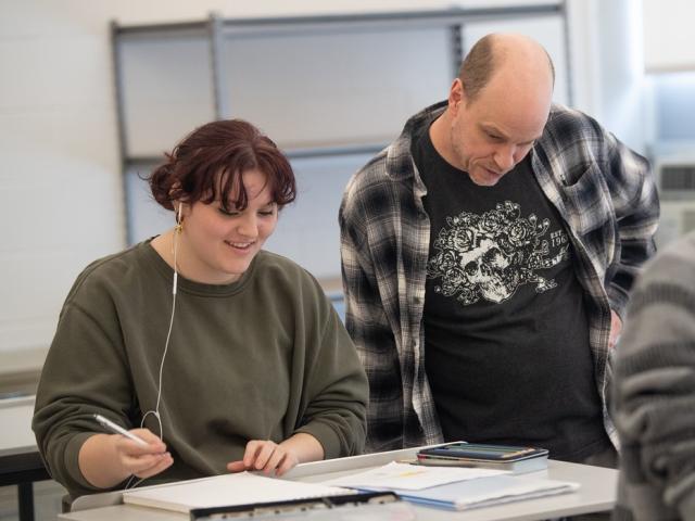 Student working on an art project with a faculty member.