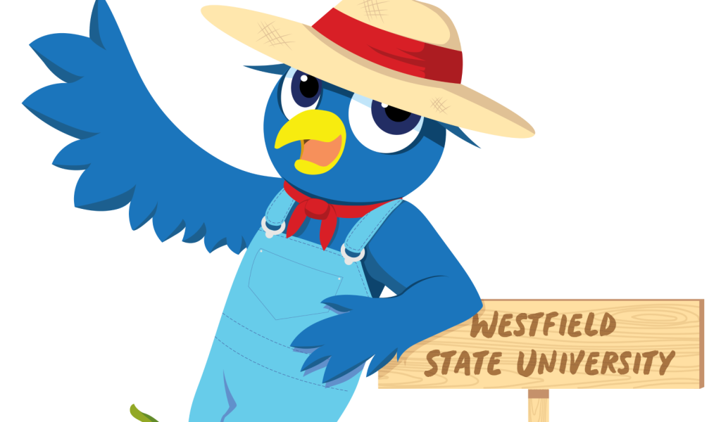 Nestor the owl mascot dressed in overalls and a straw hat, standing with pumpkins for the Family Weekend HOOT n’ Harvest theme.