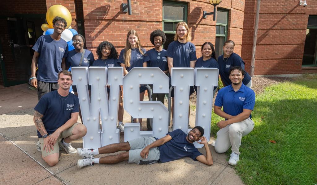 Students gathered in front of a Westfield State University sign during move-in day.
