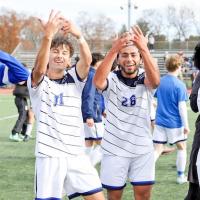 The Owls men's soccer team celebrating a game win by pointing to their ring finger, signaling their successful season.